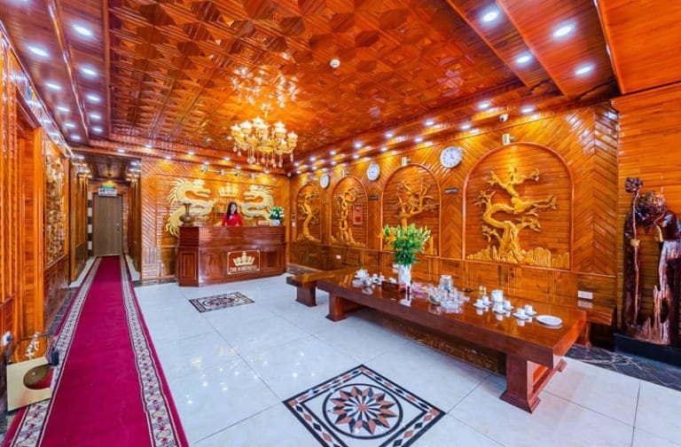 Sảnh chờ khách sạn The King Hotel Noibai toát lên vẻ vương giả với những khối gỗ bản lớn và hàng loạt chi tiết điêu khắc cầu kỳ, tỉ mỉ.