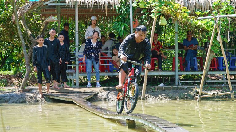 Đạp xe trên cầu sông là trò chơi thú vị đòi hỏi sự khéo léo và nhanh nhạy được khách du lịch hưởng ứng tham gia nhiệt tình