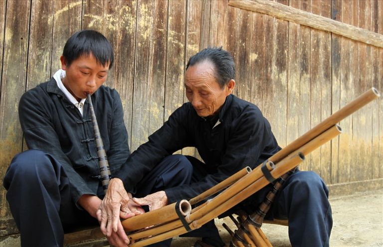 Đây là hình ảnh những nghệ nhân chuyên làm khèn Mông đang "cầm tay chỉ việc" người dân làm ra loại nhạc cụ độc đáo này