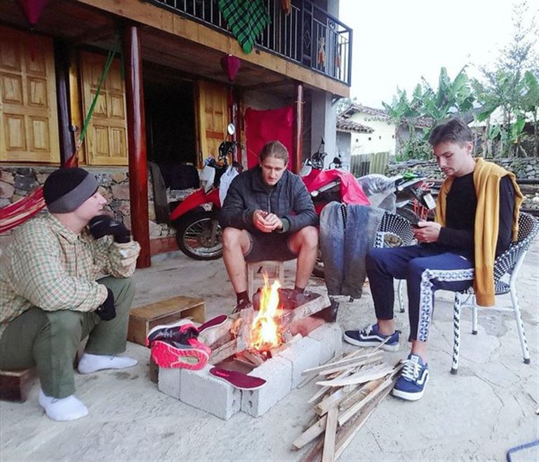Du khách ngồi quây quần bên bếp lửa để sưởi ấm và tâm sự dưới cái lạnh giá của vùng cao nguyên đá Hà Giang.