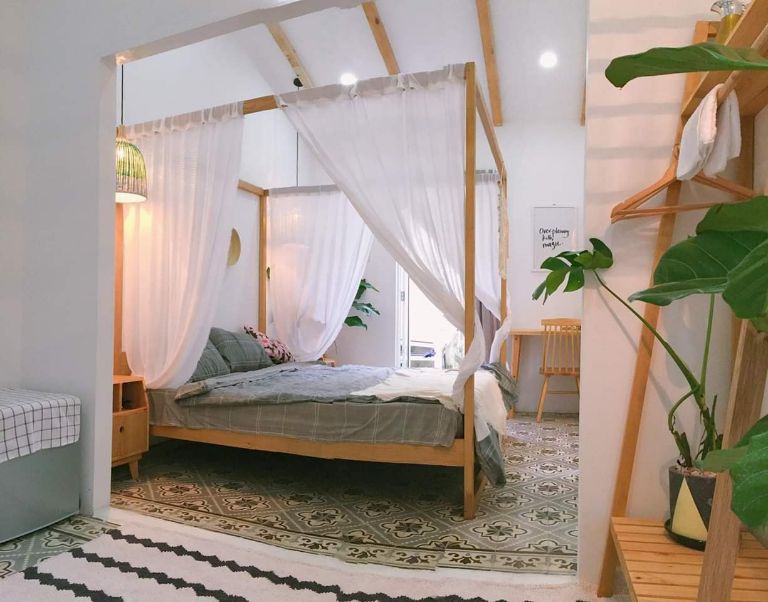 Phòng ngủ tại homestay Nha Trang với thiết kế nhẹ nhàng, điểm thêm sắc xanh của những chậu cây nhỏ tại góc phòng.