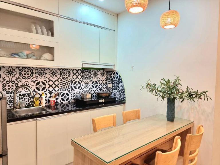 Khu vực bếp nấu ăn LaHomestay Phủ Doãn có thiết kế đơn giản ấm cúng với đèn chùm vàng (nguồn: facebook.com)