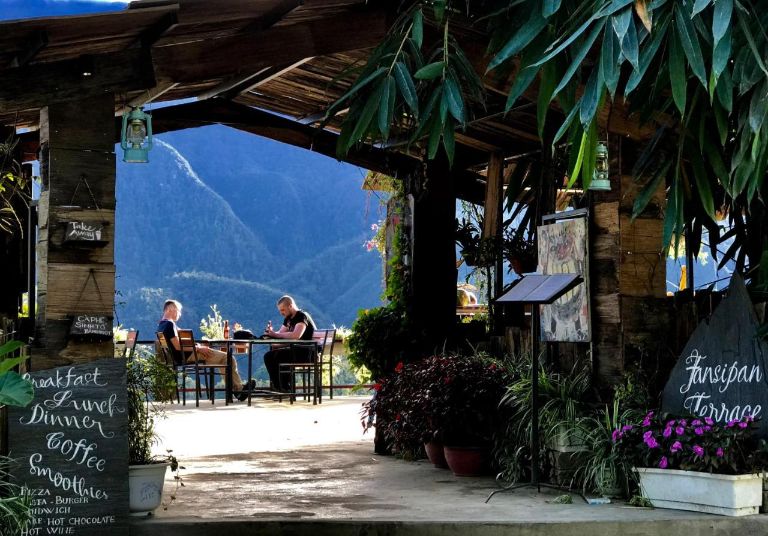 Fansipan Terrace Cafe and Homestay chào đón bạn bằng một chiếc cổng gỗ với nhiều cây lá trang trí xung quanh