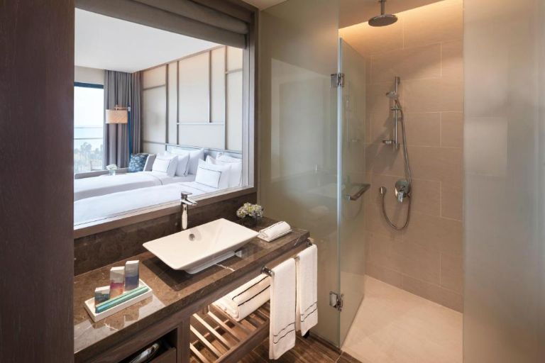 Khu vực nhà tắm Hạng phòng Deluxe thiết kế hiện đại với lồng tắm kính và lavabo nhập khẩu (nguồn: booking.com)