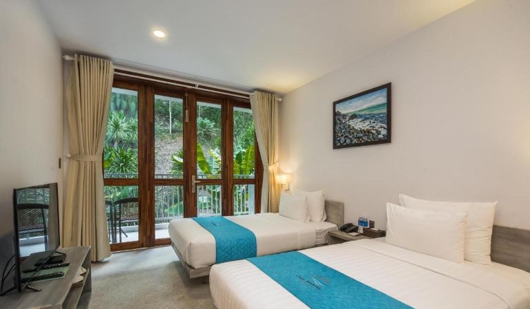 Thiết kế phòng ngủ khá đơn giản, nổi bật với cửa kính lớn thông ra ban công view biển và đồi núi.