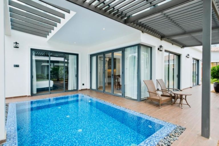 Villa có hồ bơi riêng siêu sảng chảnh, với ghế dài được trang bị bên cạnh (nguồn: Booking.com).