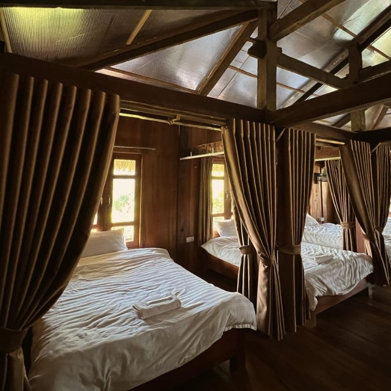 Mỗi vị trí giường tại homestay đều được trang bị một cửa sổ gỗ chạm trần, tạo nên không gian thoáng đãng và tầm nhìn rộng mở