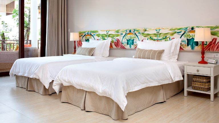 Nổi bật là khu vực đầu giường được điểm xuyết một mảng tường có họa tiết vườn sinh thái với màu sắc vô cùng sống động.