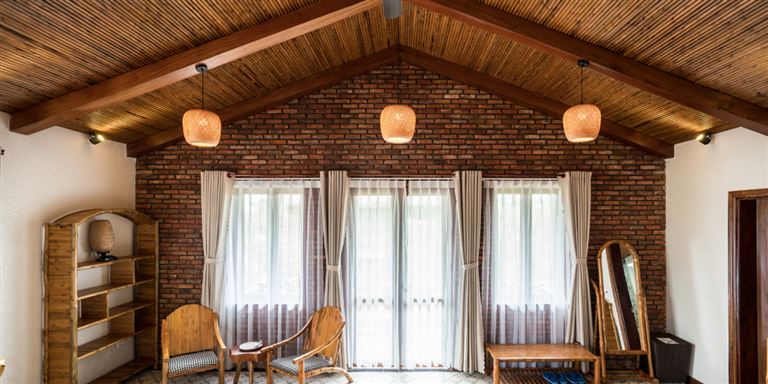 Hạng phòng Deluxe gia đình được thiết kế cổ điển với tường gạch, trần gỗ và sàn gạch men họa tiết bắt mắt. 