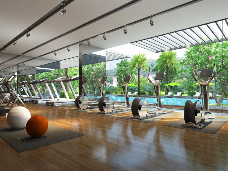 Phòng gym với một mặt tường được làm bằng kính trong suốt, mang tới tầm nhìn tuyệt đẹp tới hồ bơi và khu vườn xanh mát.