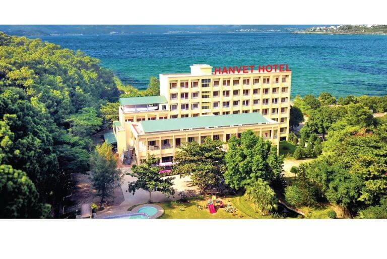 Khách sạn nổi bật với tòa nhà cao tầng màu vàng nhạt, được bao quanh bởi bãi biển và hàng cây. (Nguồn: Booking.com)