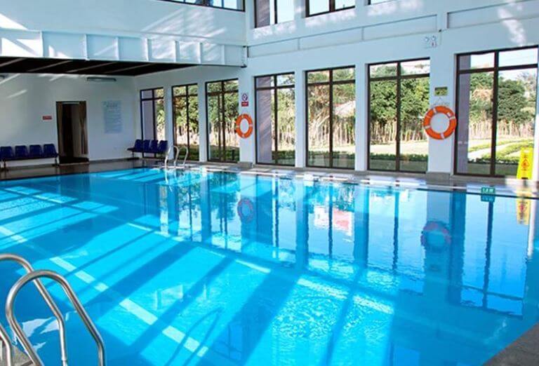 Bể bơi trong nhà có dòng nước trong xanh, thiết kế nhiều cửa kính để thu hút nguồn ánh sáng tự nhiên. (Nguồn: Booking.com)