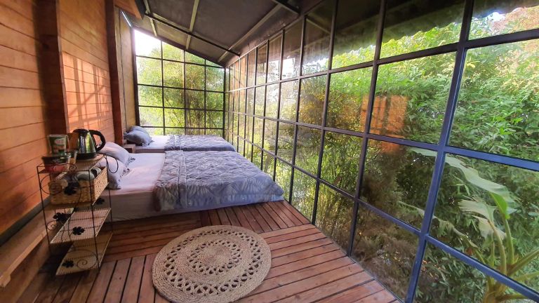 Không gian phòng ngủ tại resort Đồng Nai này vô cùng rộng thoáng nhờ thiết kế cửa kính bao quanh. 