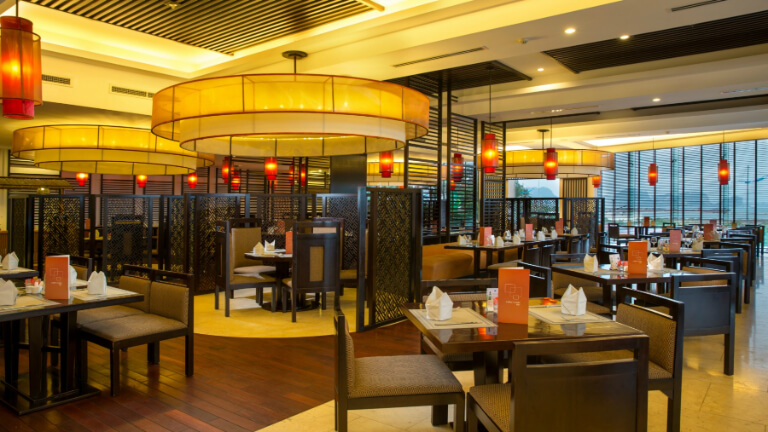 Không gian nhà hàng The Square ấm cúng với nội thất gỗ và đèn vàng dịu.