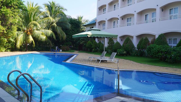  Hoà Bình Rạch Giá Resort sở hữu hồ bơi lộ thiên với thiết kế hình chữ L độc đáo, bao quanh bởi rặng dừa xanh mát. 