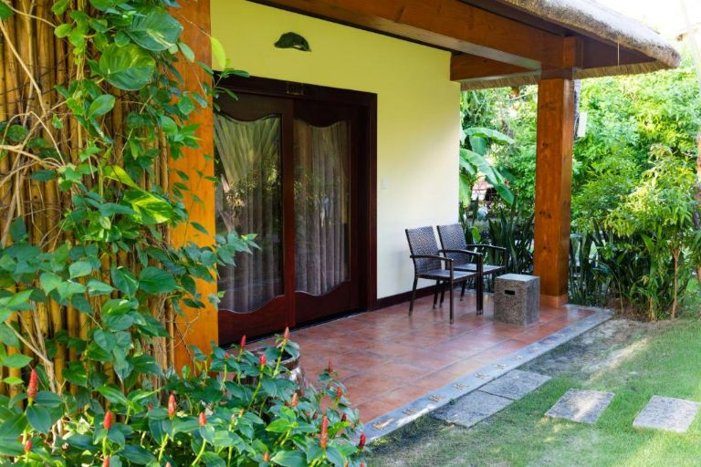 Bungalow Deluxe Garden View có sân hiên riêng trước nhà với bộ bàn ghế nhỏ, cho phép du khách ngồi chill thư giãn và tận hưởng cảnh đẹp. (Nguồn: Internet)