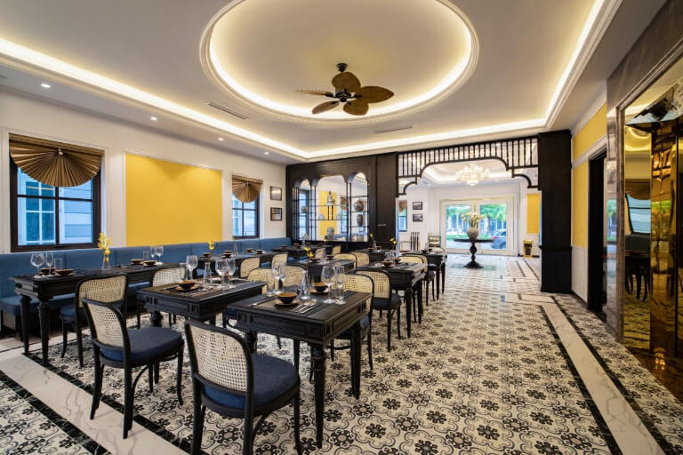 Nhà hàng tiện lợi có thiết kế giống sảnh ngoài, được bố trí bàn ghế đen gỗ điểm xanh dương.