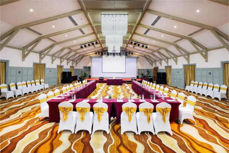 Phòng hội nghị lớn nổi bật với thảm nhiều màu và trần cong.