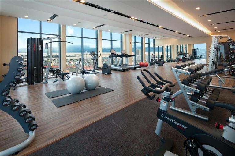 Không gian phòng tập gym sang trọng với tường kính và sàn gỗ cùng đa dạng các loại thiết bị cao cấp để khách hàng rèn luyện sức khỏe. 