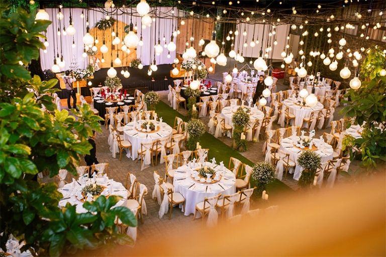 Tiệc cưới ngoài trời theo phong cách Châu Âu được decor kung kinh với hoa và hệ thống đèn mang đến không gian lãng mạn. 