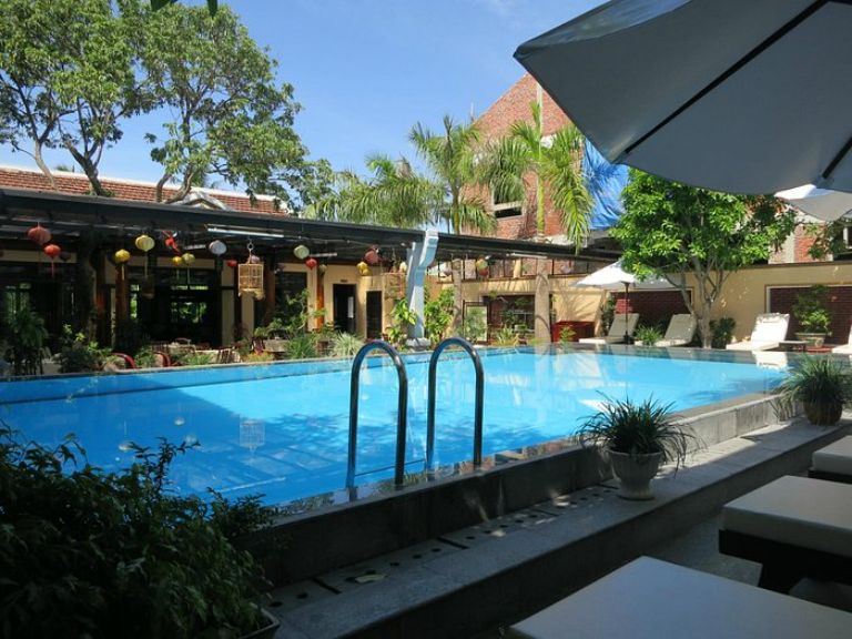 Khách sạn Huy Hoàng Hội An sở hữu bể bơi ngoài trời được trang trí trong không gian tràn ngập sắc màu của đèn lồng và cây cối.
