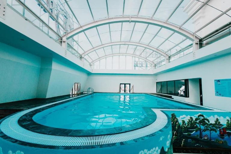 Dragon Legend Ha Long Hotel với bể bơi được thiết kế hiện đại với vòm kính và được decor các bức núi đá và cây xanh.