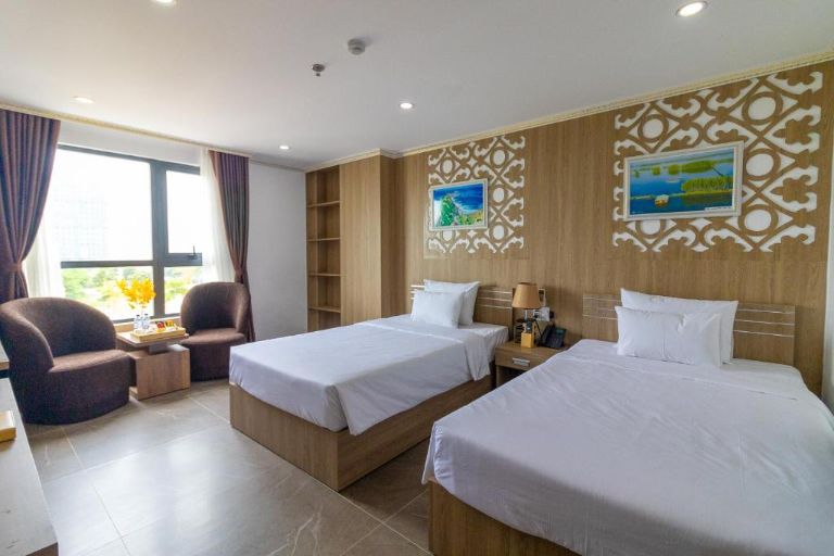 Phòng nghỉ tại khách sạn mang đến không gian ấm cúng với các gam màu trầm tối giản. (nguồn: Booking.com).