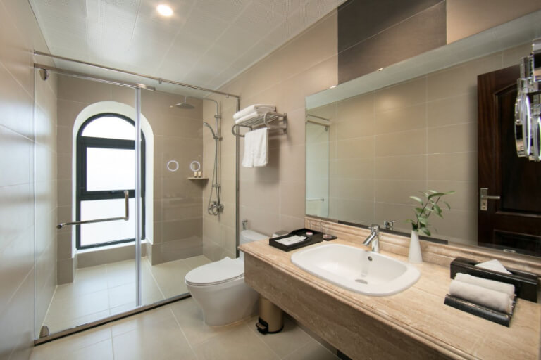 Phòng vệ sinh sáng sủa, hiện đại nhờ hệ thống cửa sổ bên ngoài ngay khu vực phòng tắm kính.