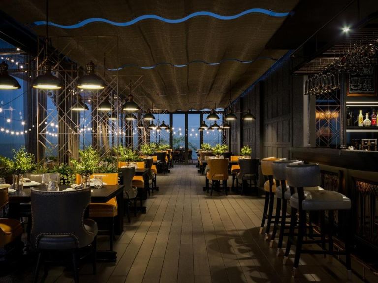 Sky Lounge là quán cafe và bar mang lối thiết kế độc đáo với trần nhà uốn lượn, trang bị nhiều cây xanh và ánh đèn vàng lấp lánh.