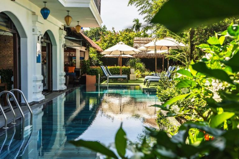 Odyssey Hotel Hoi An với hồ bơi 4 mùa được bao quanh là cây xanh của khu vườn, có ghế tắm nắng và quầy bar phục vụ nước uống.