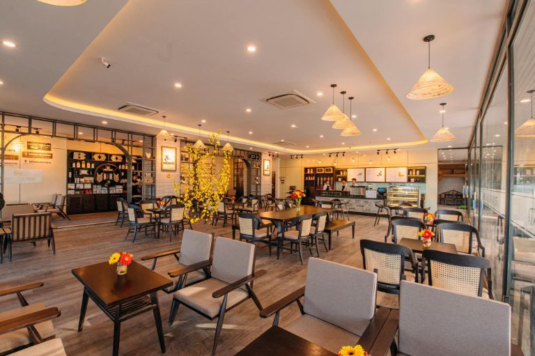 Hoàng Long Hotel sở hữu một quán cafe được thiết kế sang chảnh với kiến trúc đương đại với gỗ mun sáng và hệ thống kính trong suốt. 