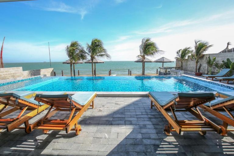 Khách sạn Serenity By The Sea với bể bơi diện tích cực lớn 40m2, phía trước là biển và được bao quanh là rặng dừa.