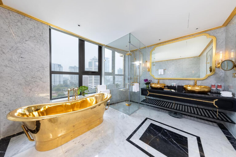 Phòng vệ sinh nổi bật với bồn tắm dát vàng lớn.