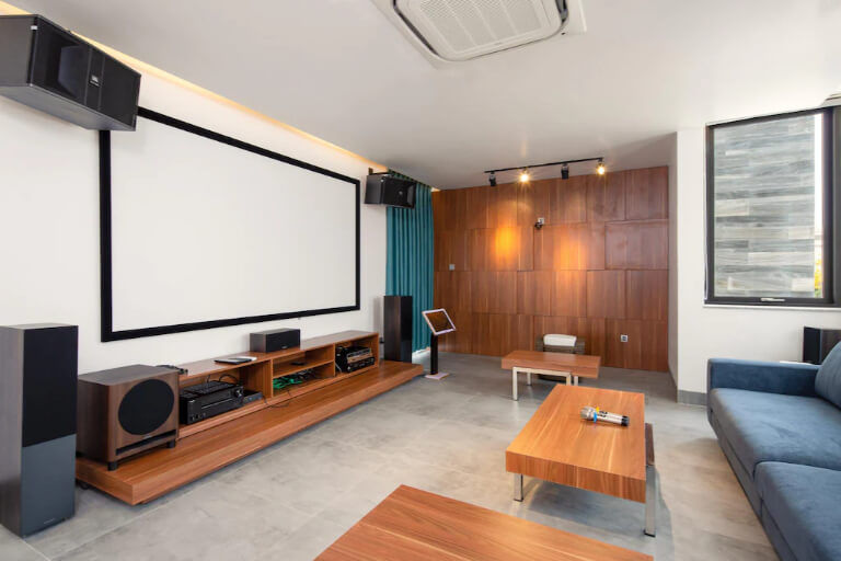 Không gian phòng khách hiện đại được bố trí dàn âm thanh và máy chiếu chất lượng.