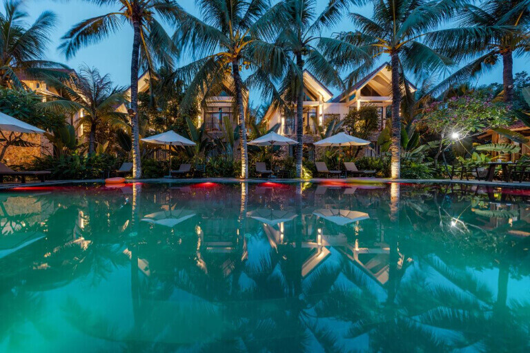 Bể bơi nằm chính giữa khuôn viên, được bao quanh bởi hàng cây dừa cạn.